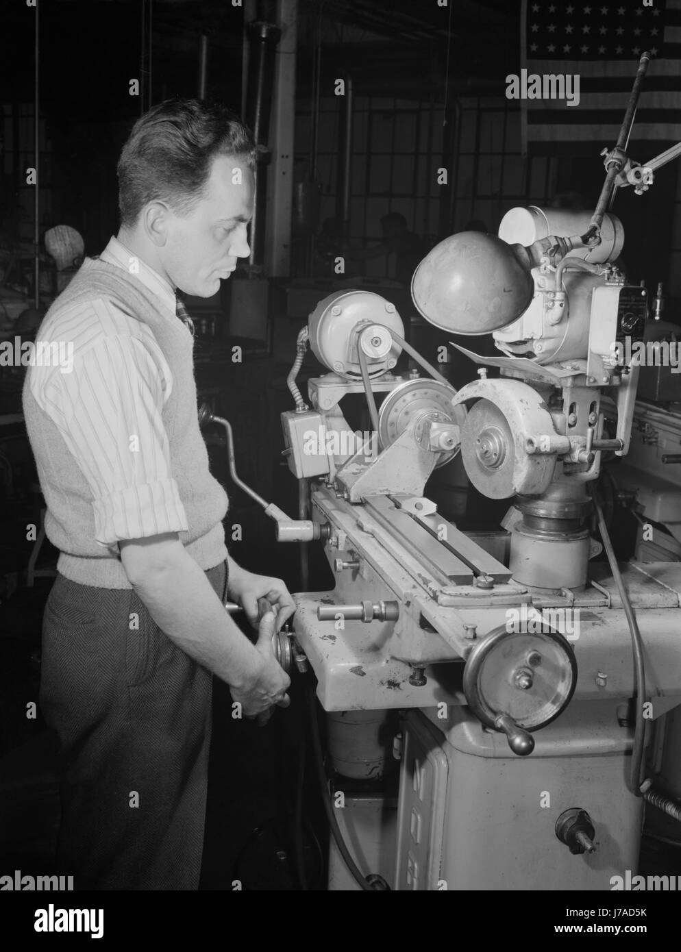 A skilled worker grinds permanent magnet rotors during WW2 war efforts, 1942. Stock Photo