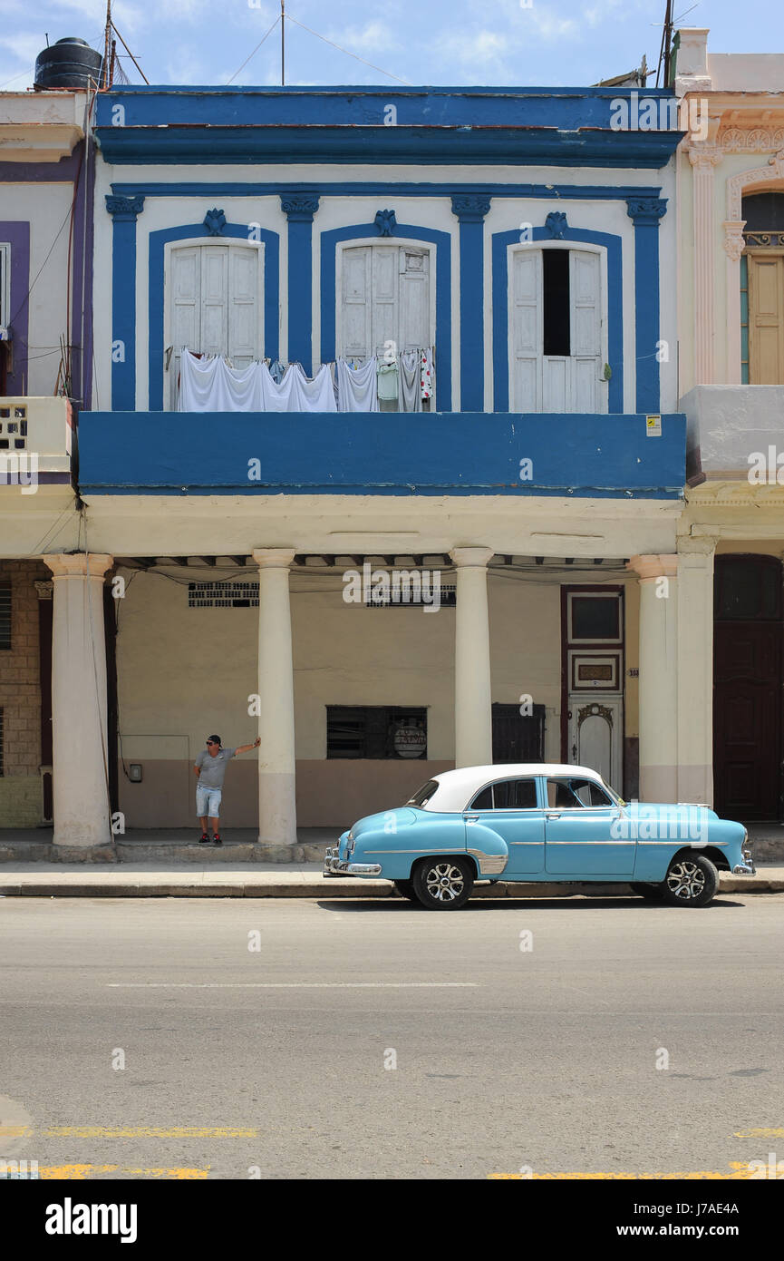 Typical street scene in Old Havana : colourful buildings and old american classic cars driving by Stock Photo
