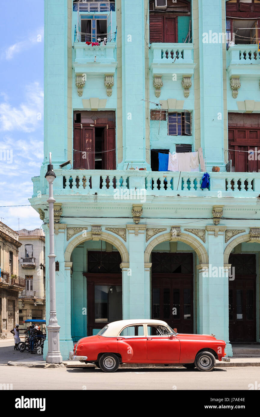 Typical street scene in Old Havana : colourful buildings and old american classic cars driving by Stock Photo