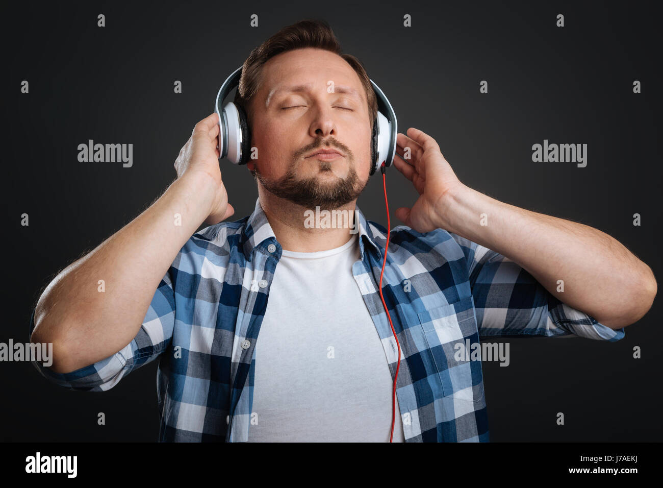 Handsome dreamy man caught in music Stock Photo