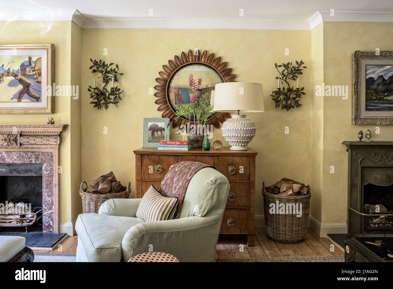 Traditional english style living room with Howard style armchair, sun burst  gilt mirror and original fireplace Stock Photo - Alamy, image size:1300x957