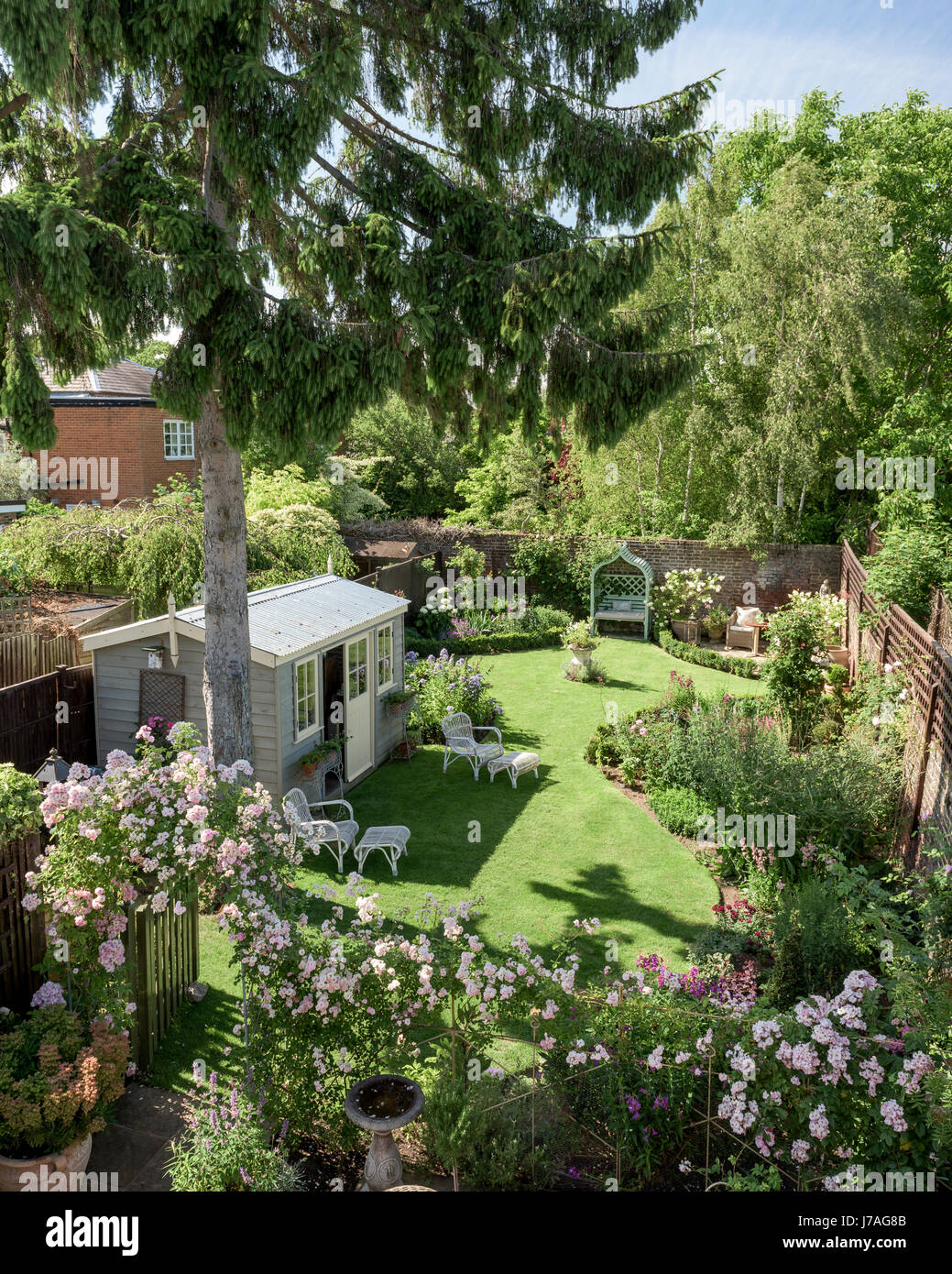 View from balcony down to english walled garden with summer house and rose arch Stock Photo