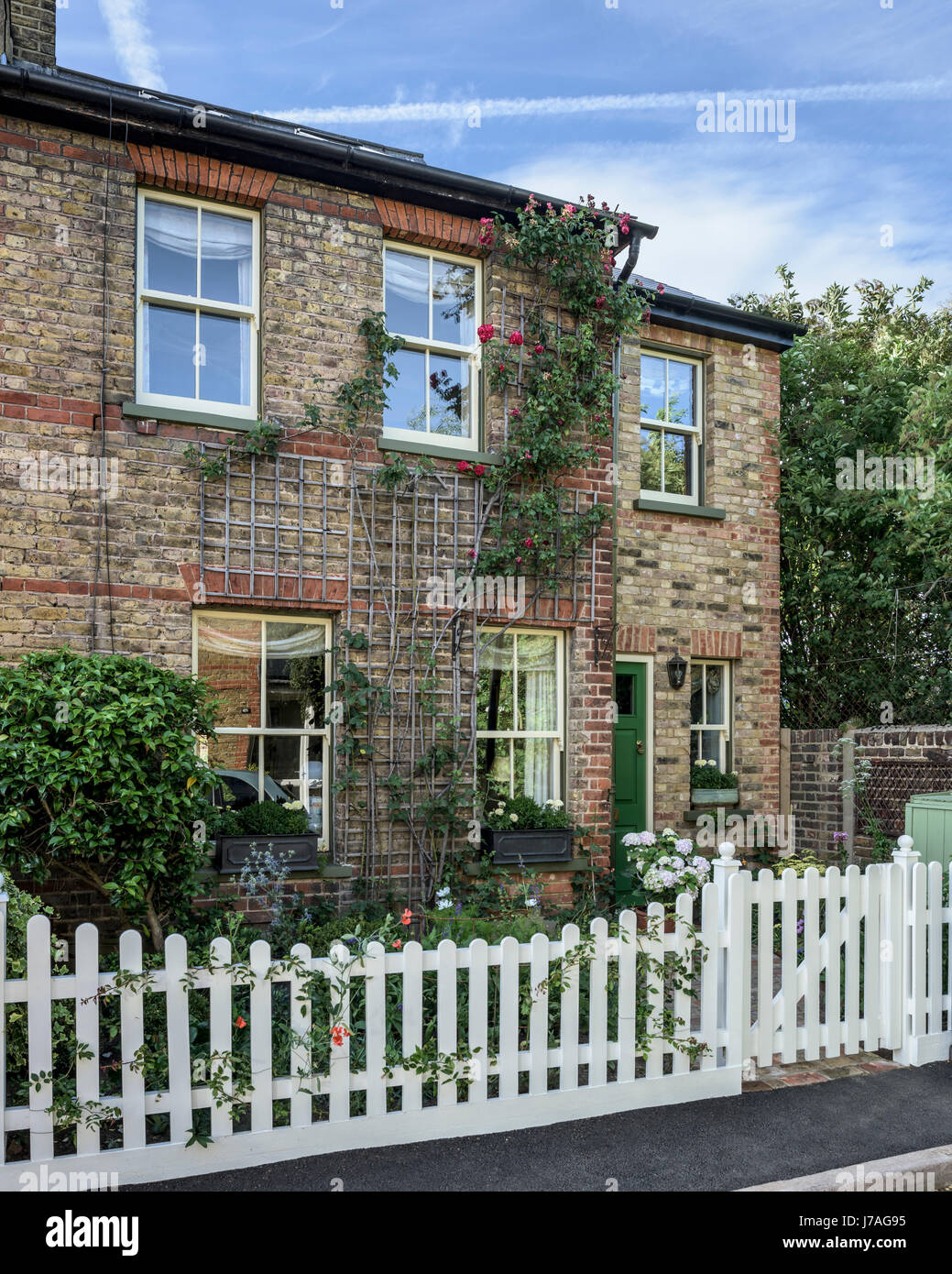 Exterior facade of late Victorian cottage with tiled path and green front door Stock Photo