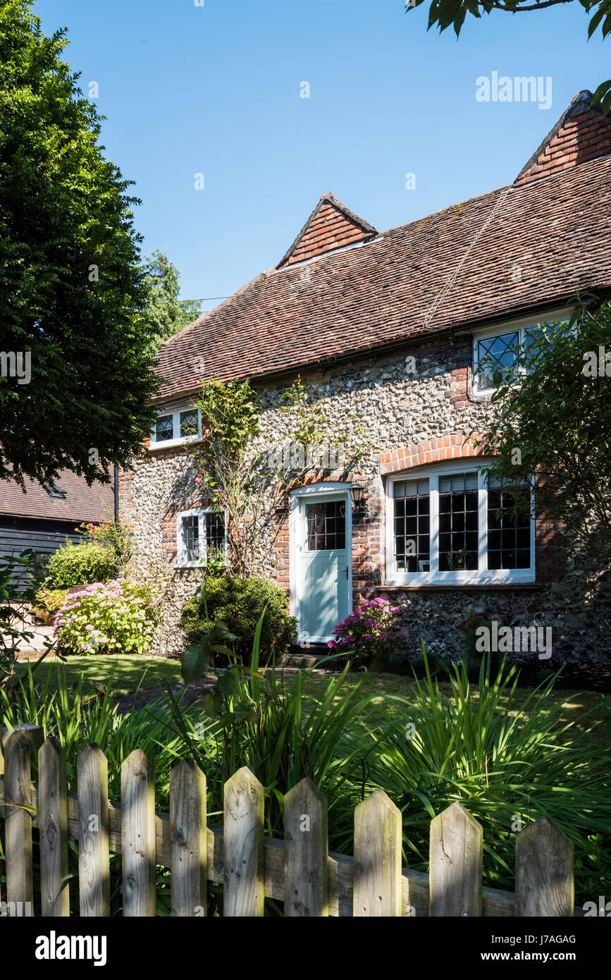 External facade of idyllic Grade II brick and flint cottage Stock Photo