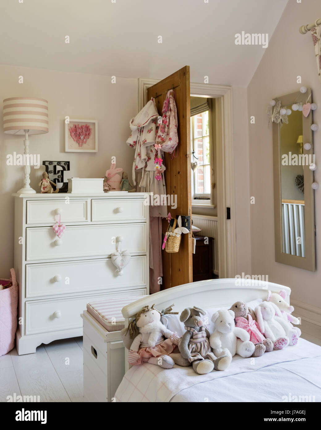 Assorted teddy bears on bed in childs bedroom, the chest of drawers is painted in Farrow & Ball's Pointing by Fairlily Stock Photo