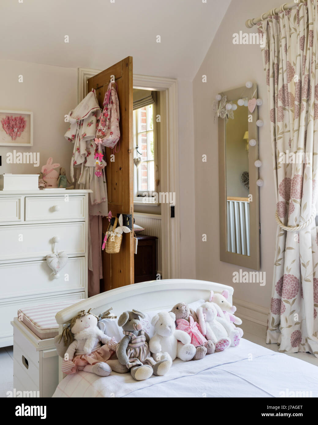 Assorted teddy bears on bed in childs bedroom, the chest of drawers is painted in Farrow & Ball's Pointing by Fairlily Stock Photo