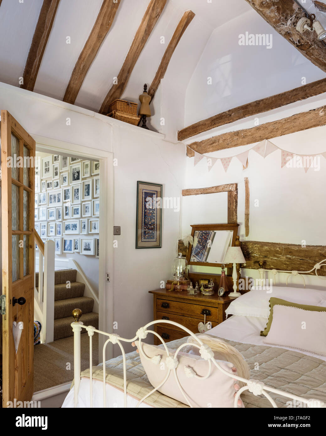 Vaulted master bedroom with ancient beams and wrought iron bed from The Iron Bed company Stock Photo