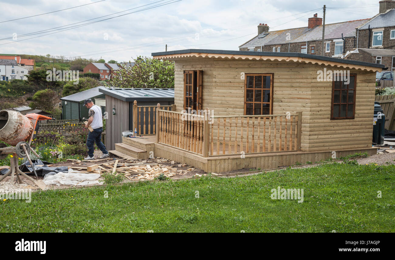 A joiner working on building an outhouse at Staithes,North Yorkshire,England,UK Stock Photo