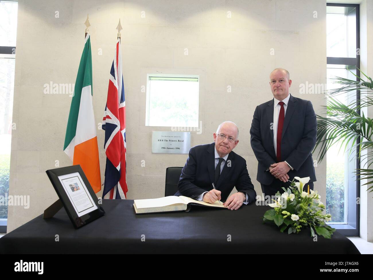 Minister for Foreign Affairs Charlie Flanagan, with Deputy Head of Mission Neil Holland (right), signs a book of condolence at the British Embassy in Dublin for those affected by the attack in Manchester. Stock Photo