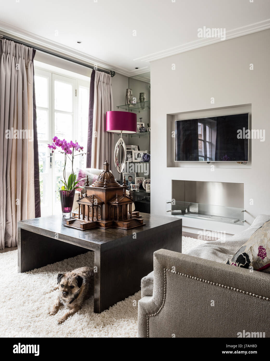 Fuschia satin shade with scale model on dark wood table in  Victorian terrace, London Stock Photo