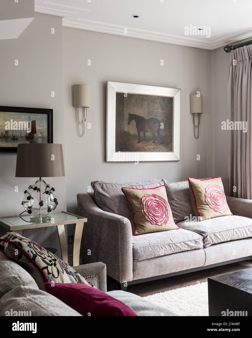 Equestrian artwork above sofa with rose cushions in Victorian terrace, London Stock Photo