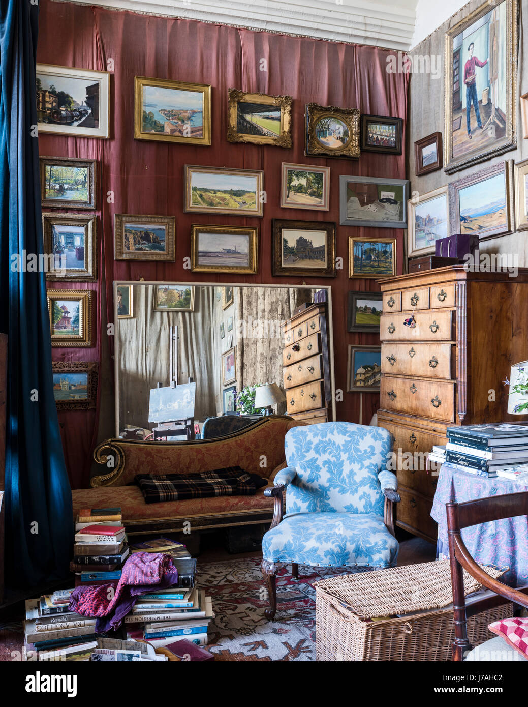 Acanthus leaf print upholstered armchair in bohemian studio space full of Julian Barrow paintings Stock Photo