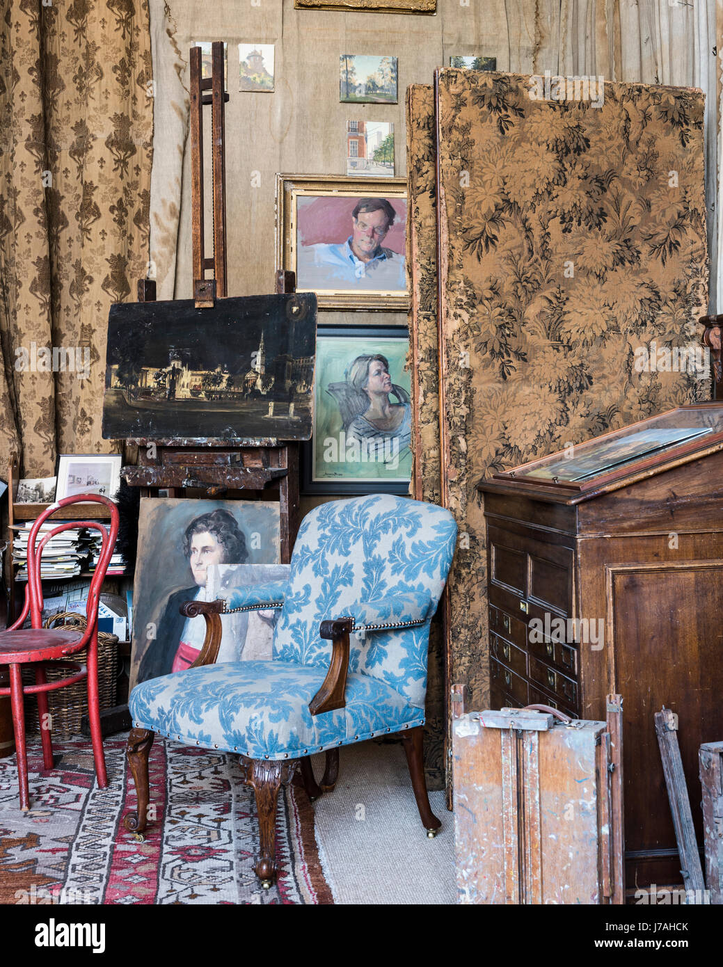 Acanthus leaf print upholstered armchair in bohemian studio space full of Julian Barrow paintings Stock Photo