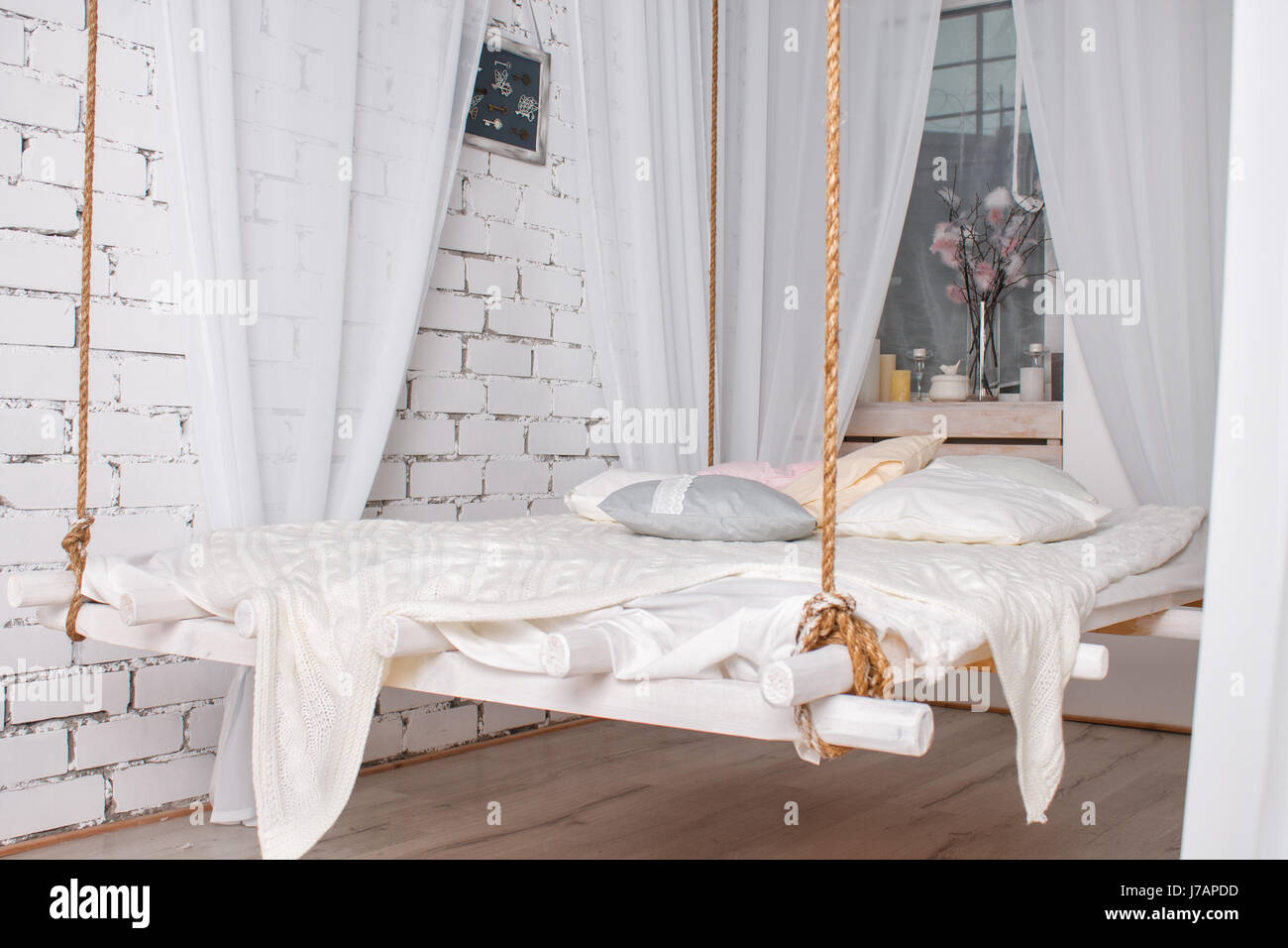 White Loft Interior With Hanging Bed Suspended From The Ceiling