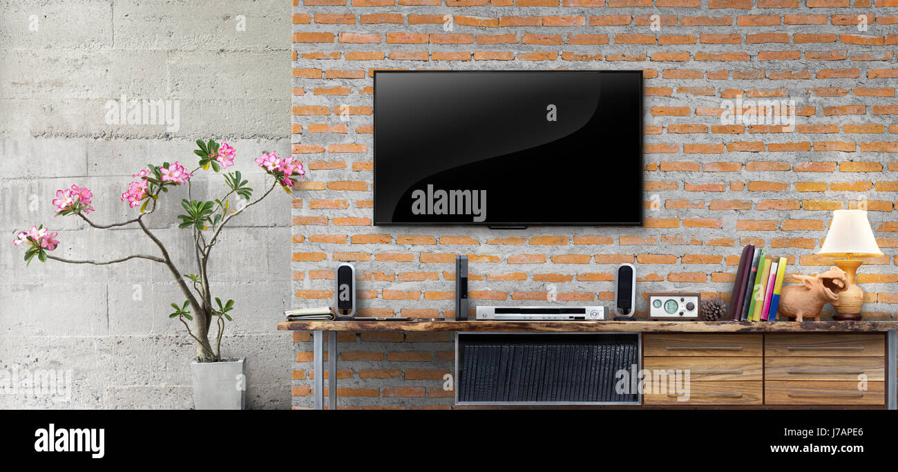 Tv on red brick wall with wooden table in living room interior Stock Photo