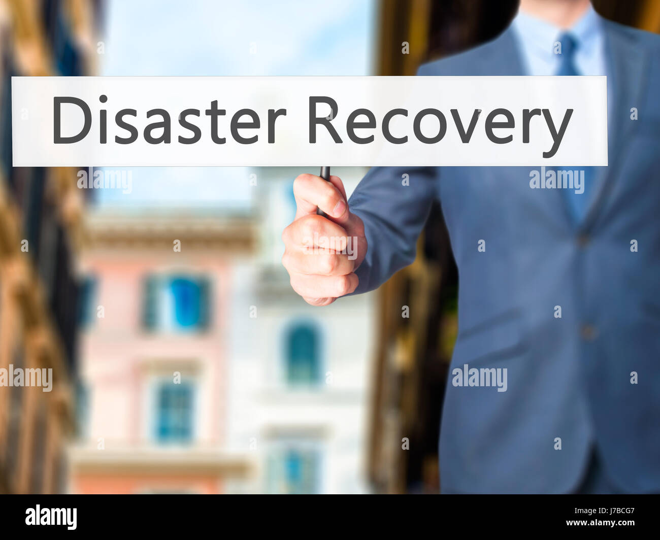 Disaster Recovery - Businessman hand holding sign. Business, technology, internet concept. Stock Photo Stock Photo
