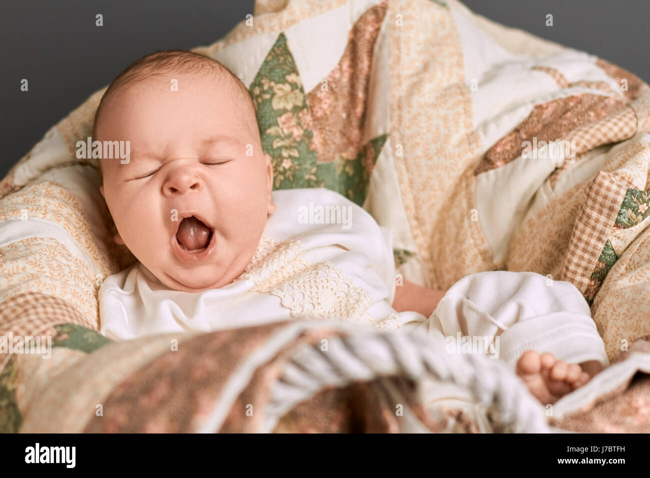Caucasian baby yawning. Small child with mouth open. Tired signs in infant. Stock Photo
