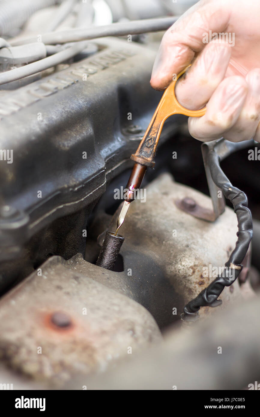 Pulling the oil level dipstick out of the engine. Measurement of engine