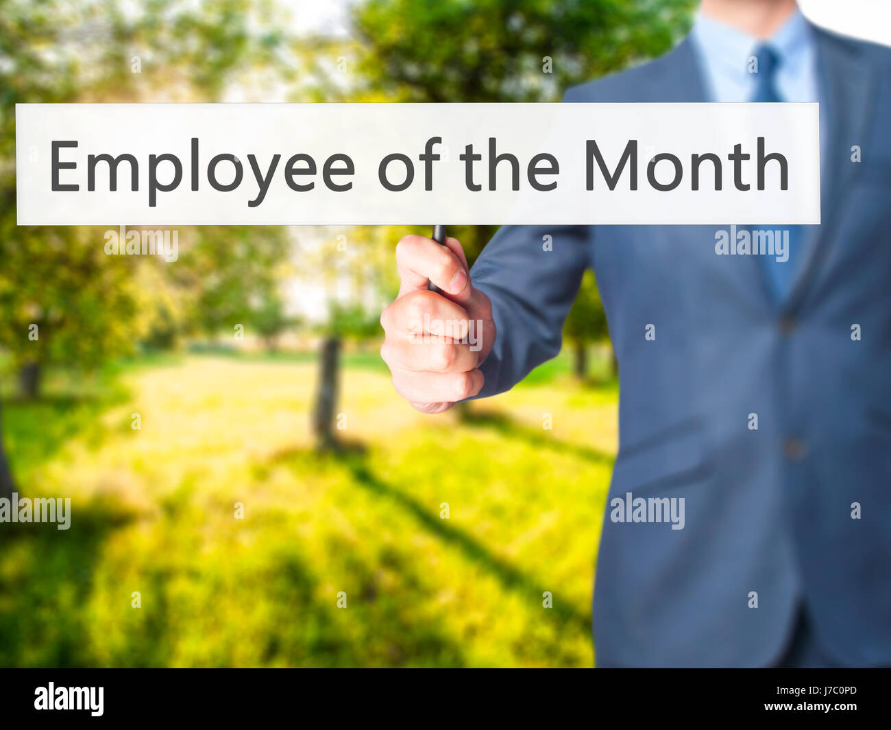 Employee of the Month - Businessman hand holding sign. Business, technology, internet concept. Stock Photo Stock Photo