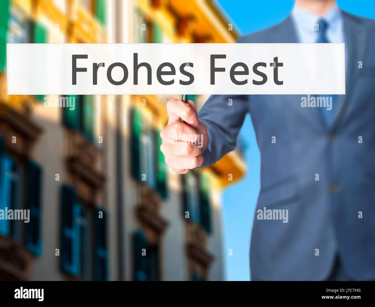 frohes fest (Happy Christmas in German) - Businessman hand holding sign. Business, technology, internet concept. Stock Photo Stock Photo
