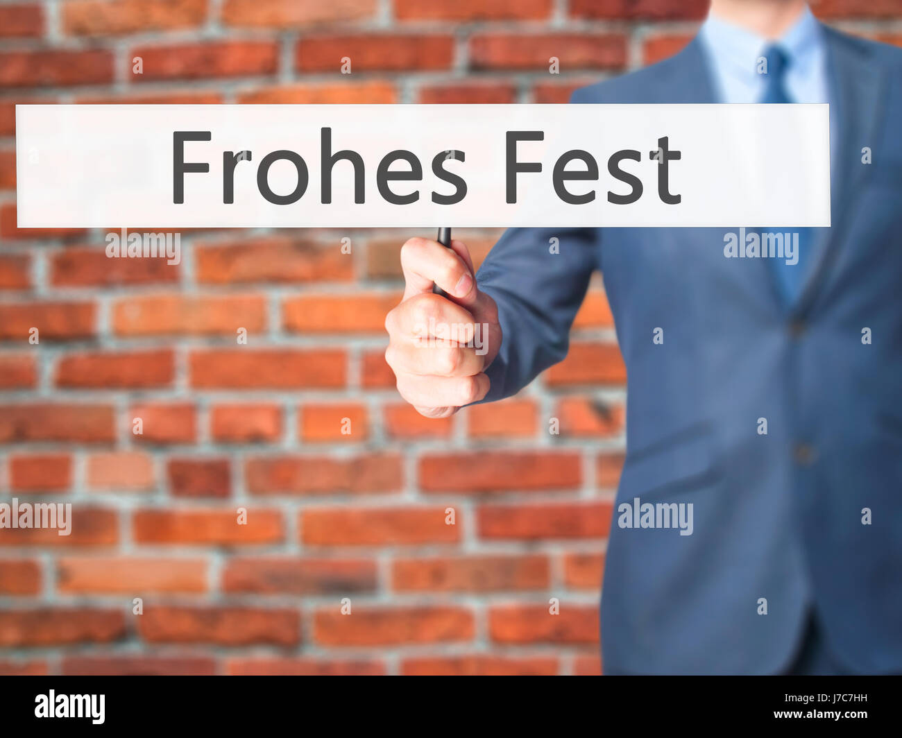frohes fest (Happy Christmas in German) - Businessman hand holding sign. Business, technology, internet concept. Stock Photo Stock Photo