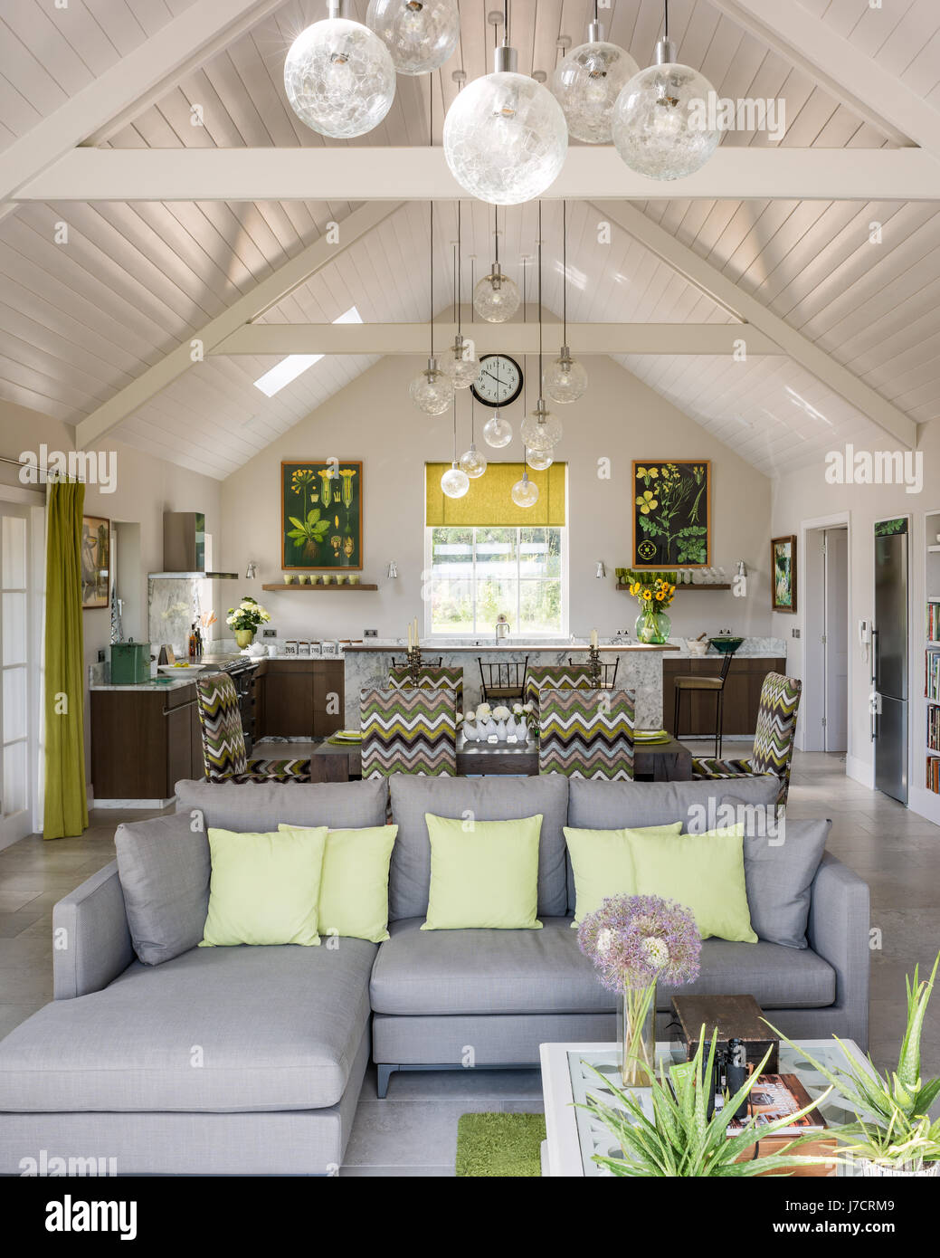 Open plan space with vintage glass globes grouped to define areas and botanical prints inspiring colour Stock Photo