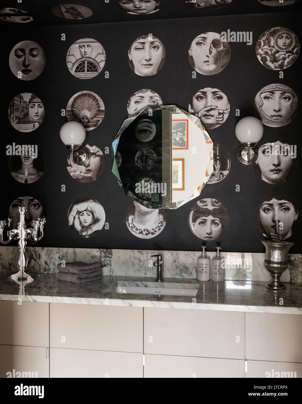 Fornasetti wallpaper in marble bathroom with vintage mirror Stock Photo -  Alamy