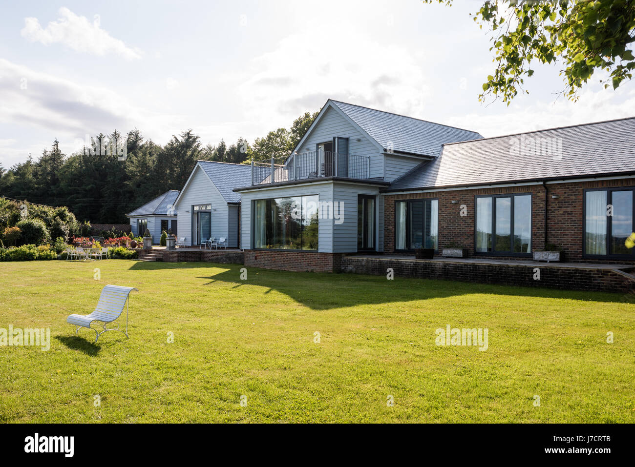 Exterior weatherboard of renovated Sussex bungalow, painted in grey to blend to natural landscape Stock Photo