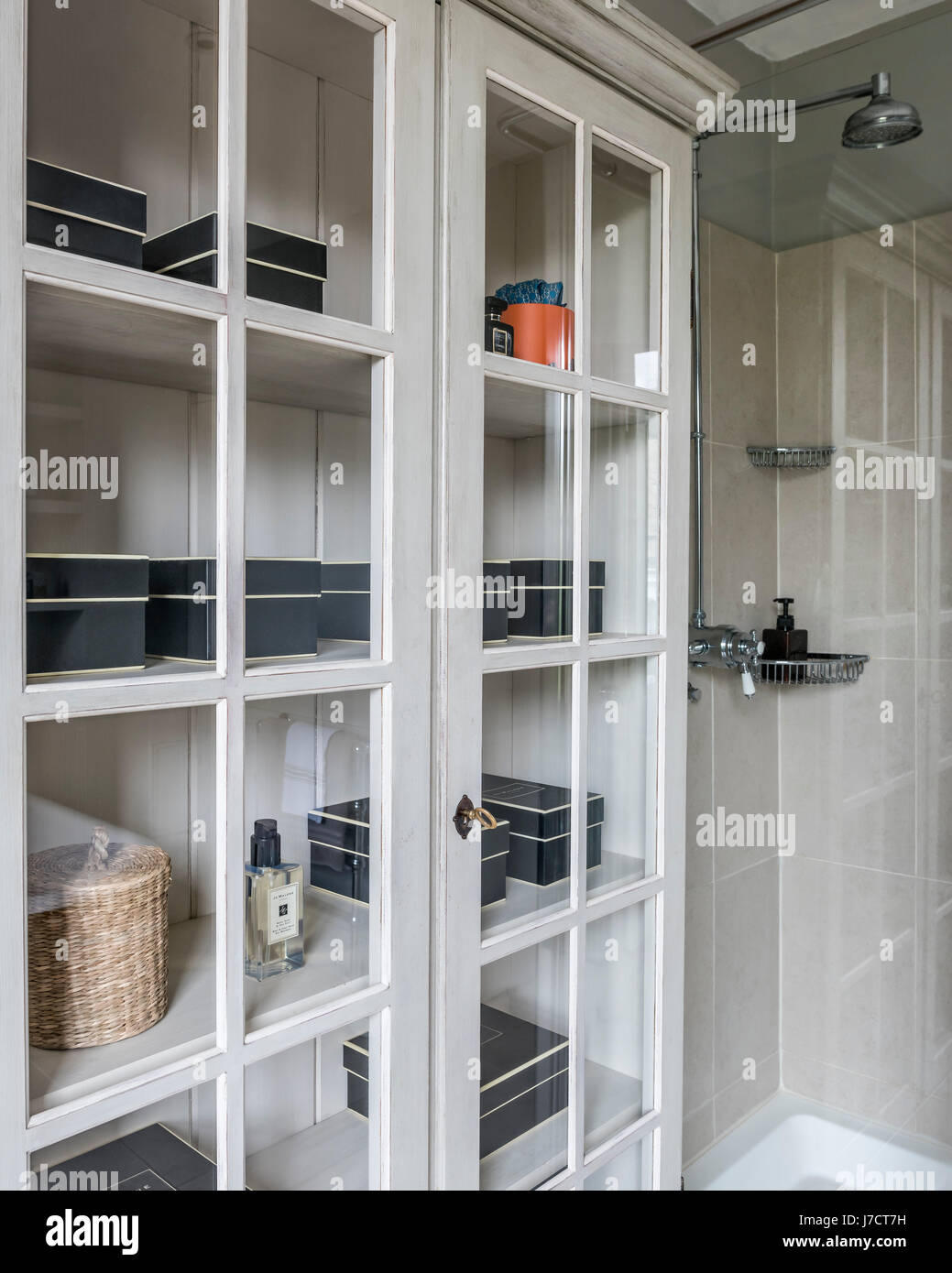 Jo Malone boxes in cupboard with glass fronted panels Stock Photo