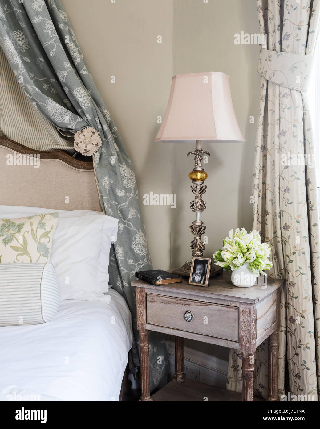 Detail of elegant bedside table with lamp and family photograph Stock