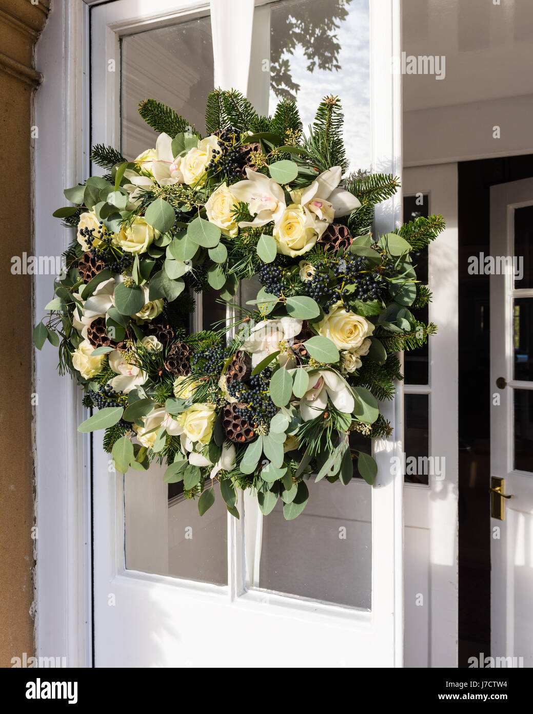 A beautiful handmade wreath from twisted willow, white roses and lotus flowers on front door Stock Photo