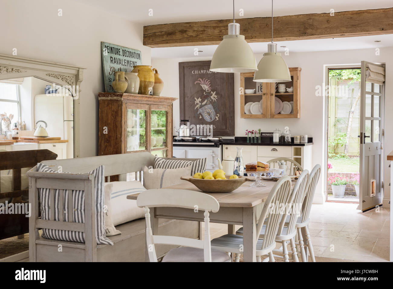 Open plan rustic kitchen diner with French / Scandinavian feel. The table and chairs come from Haus and the cushions are from Cabbages & Roses. The pe Stock Photo