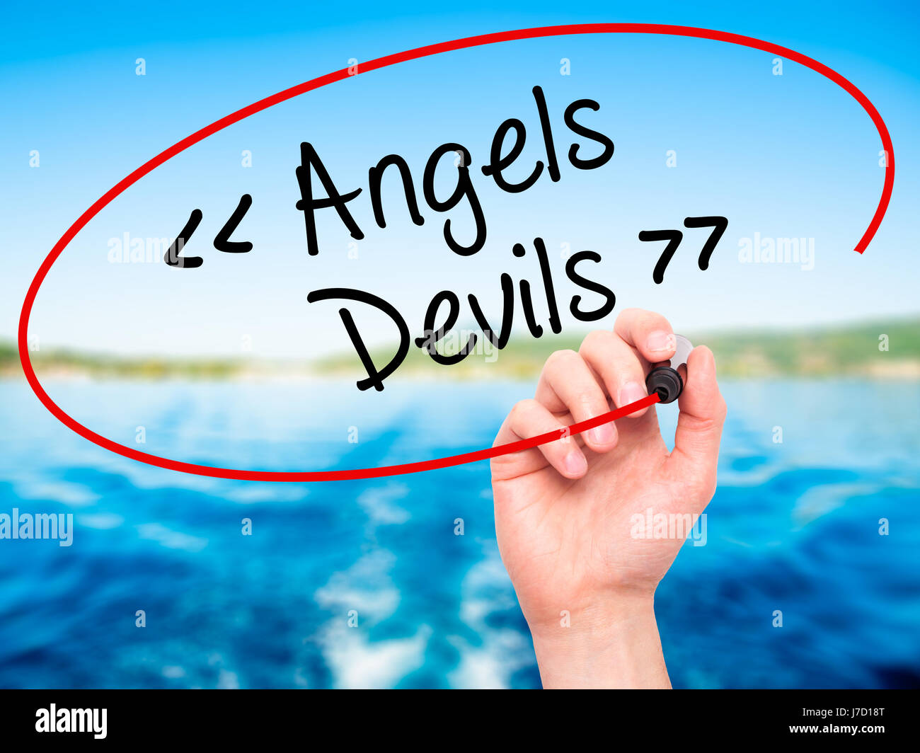 Man Hand writing Angels - Devils with black marker on visual screen ...