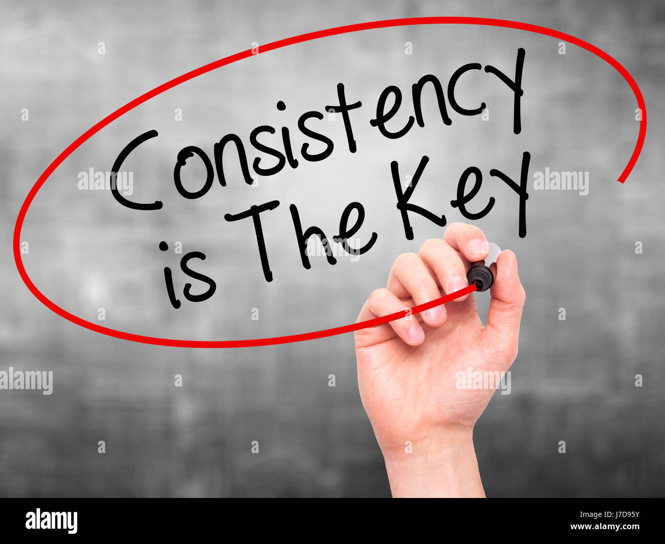 Man Hand writing Consistency is The Key with black marker on visual ...