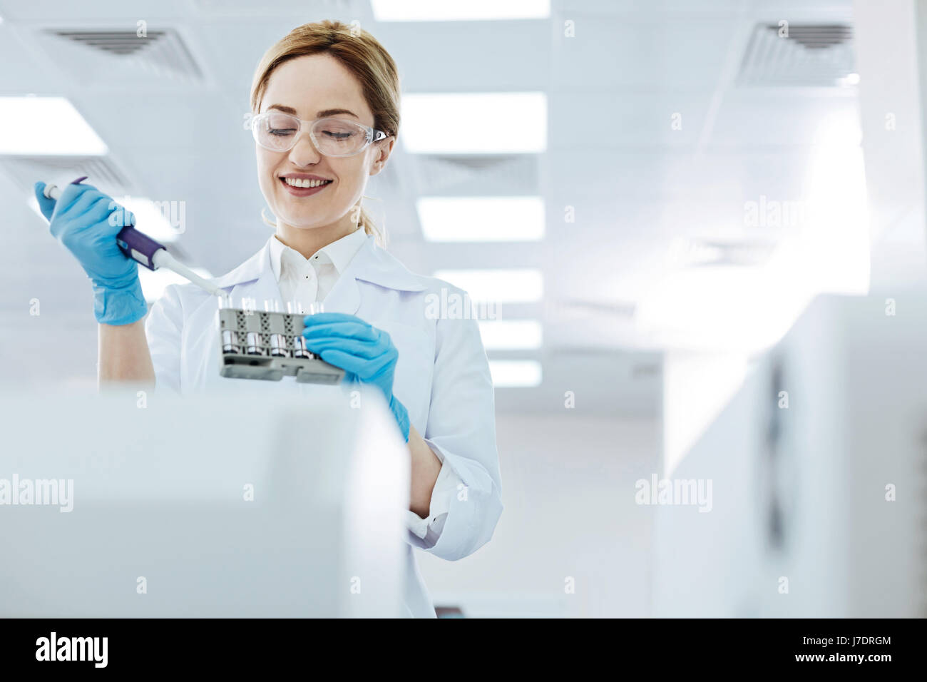 Positive delighted female scientist doing experiment Stock Photo