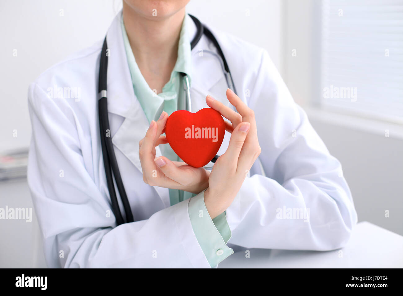 Female doctor with stethoscope holding heart. Cardio therapeutist, physician make cardiac