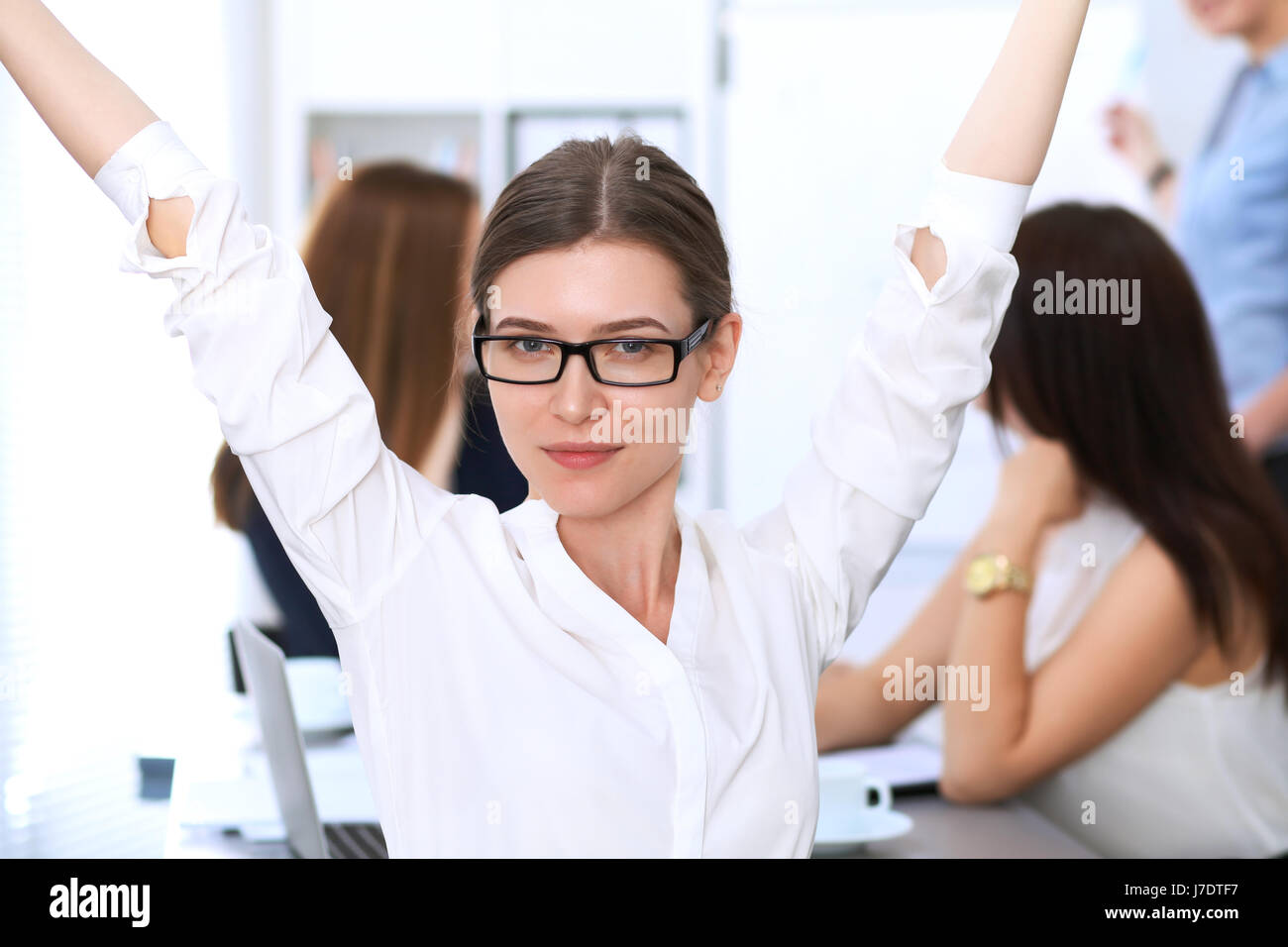 Portrait of a young business woman against a group of business people ...