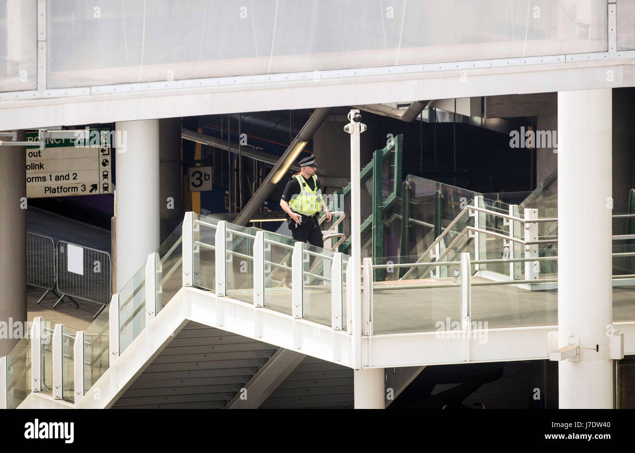 A police officer walks up steps leading from Victoria railway station to Manchester Arena after a suicide bomber killed 22 people leaving a pop concert at the venue on Monday night. Stock Photo