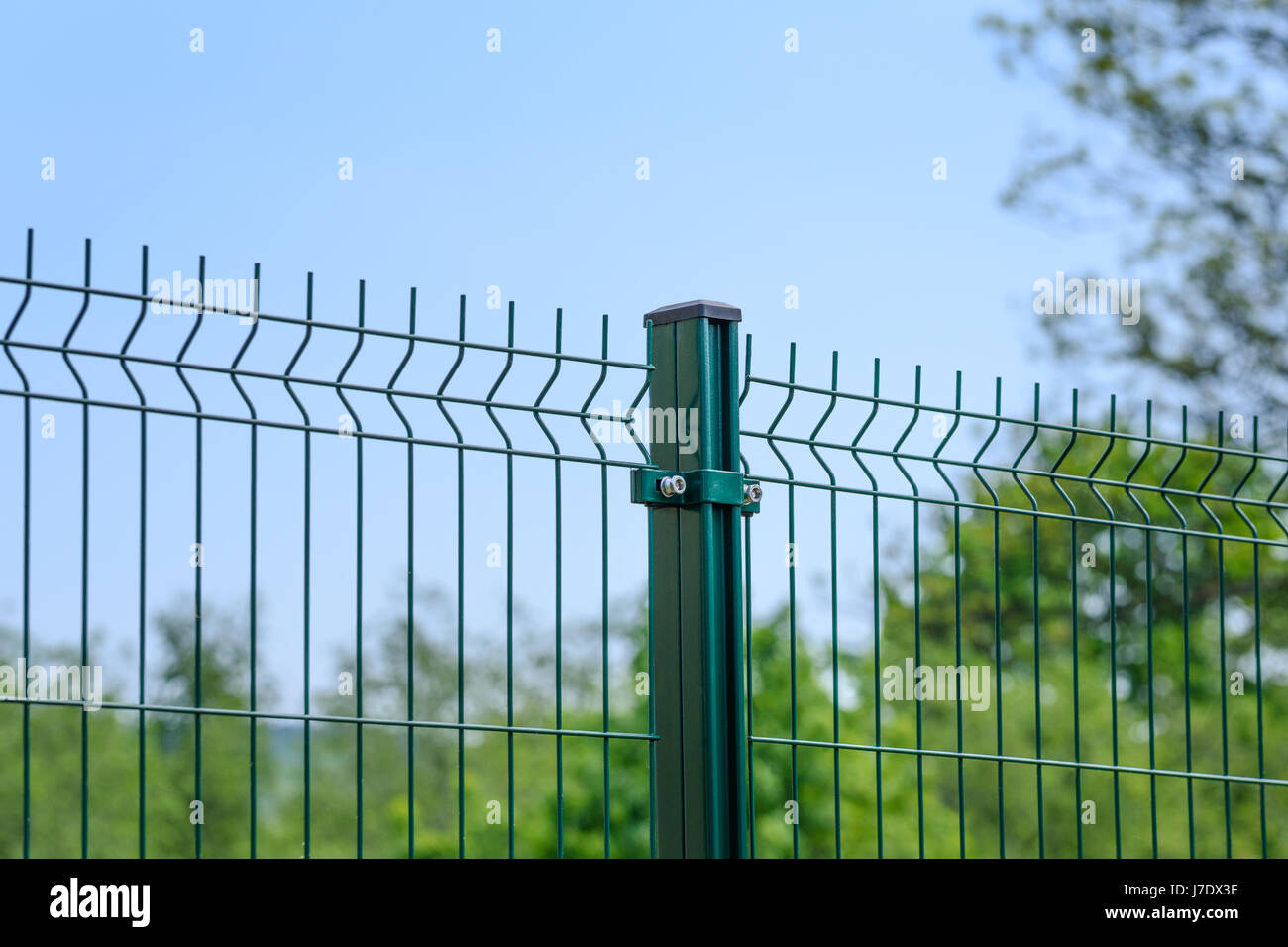Close-up of a metal fence wire on blue sky background Stock Photo