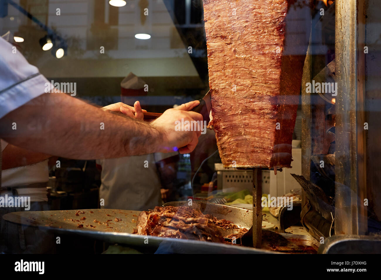 An arm moving to cut the kebab meat Stock Photo Alamy