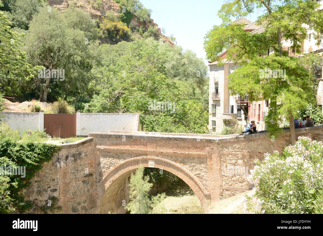 People on brick bridge over the river Darro in Granada, Andalusia, Spain. Stock Photo