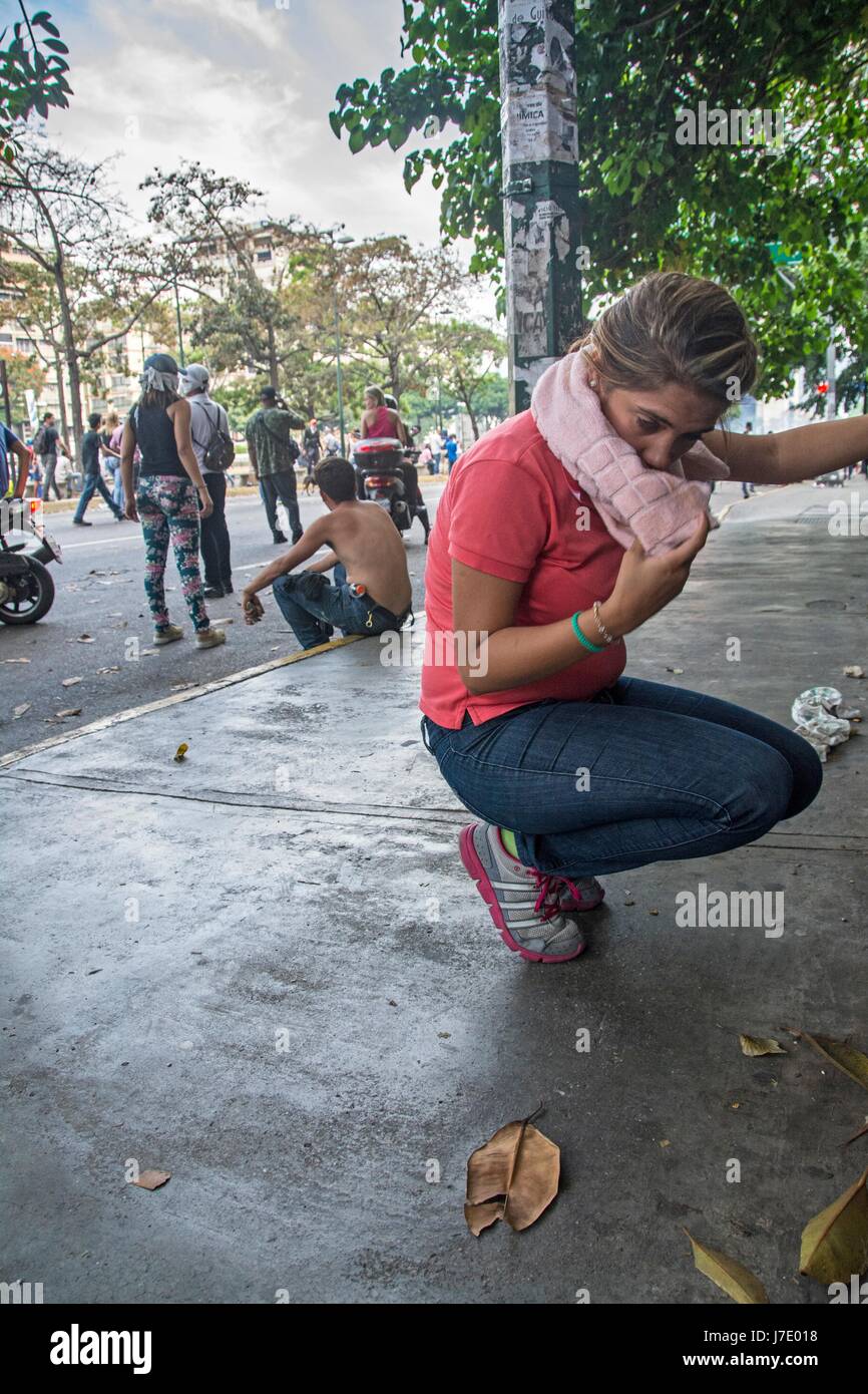 A girl covers herself  faces and antacid and water are placed with bicarbonate to counteract the effect of tear gas pumps. Deputies of the MUD and fol Stock Photo