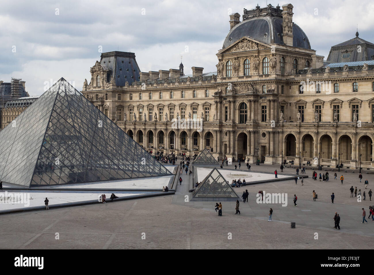 The Louvre Museum glass pyramid with building in background, Paris France Stock Photo