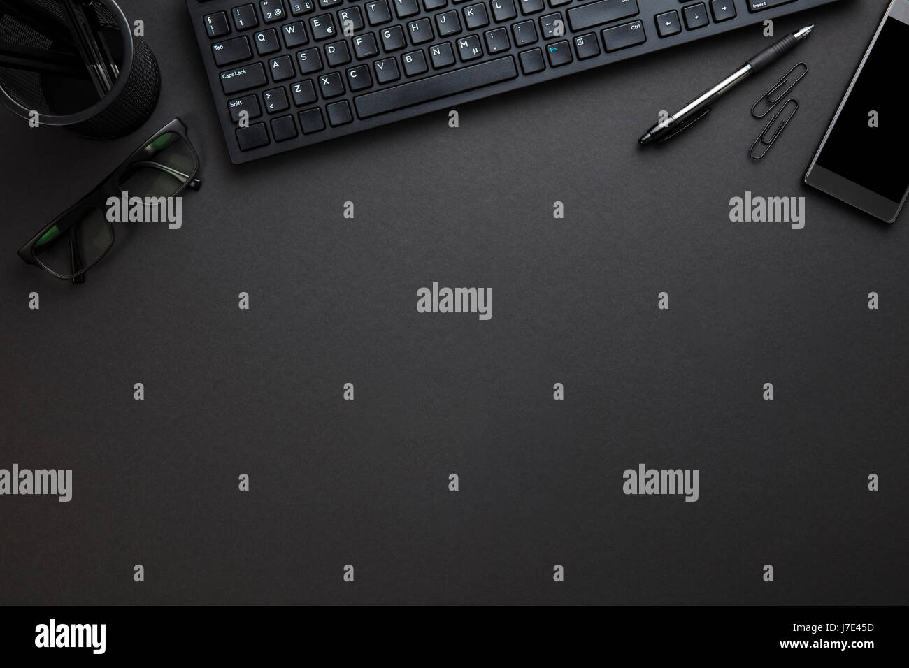 Computer Keyboard With Eyeglasses And Office Supply On Gray Desk Stock Photo