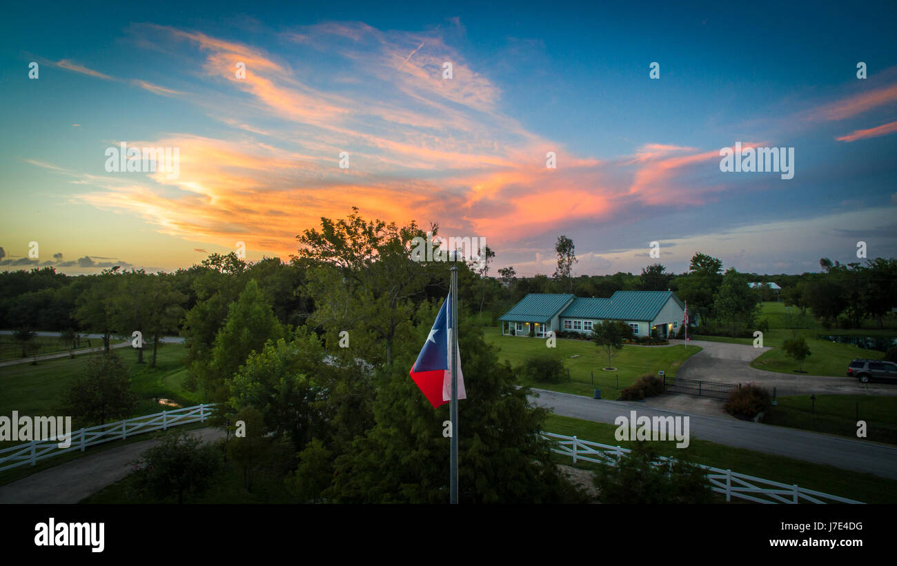Aerial shoot of the Texas flag flying high over a beautiful sunset Stock Photo