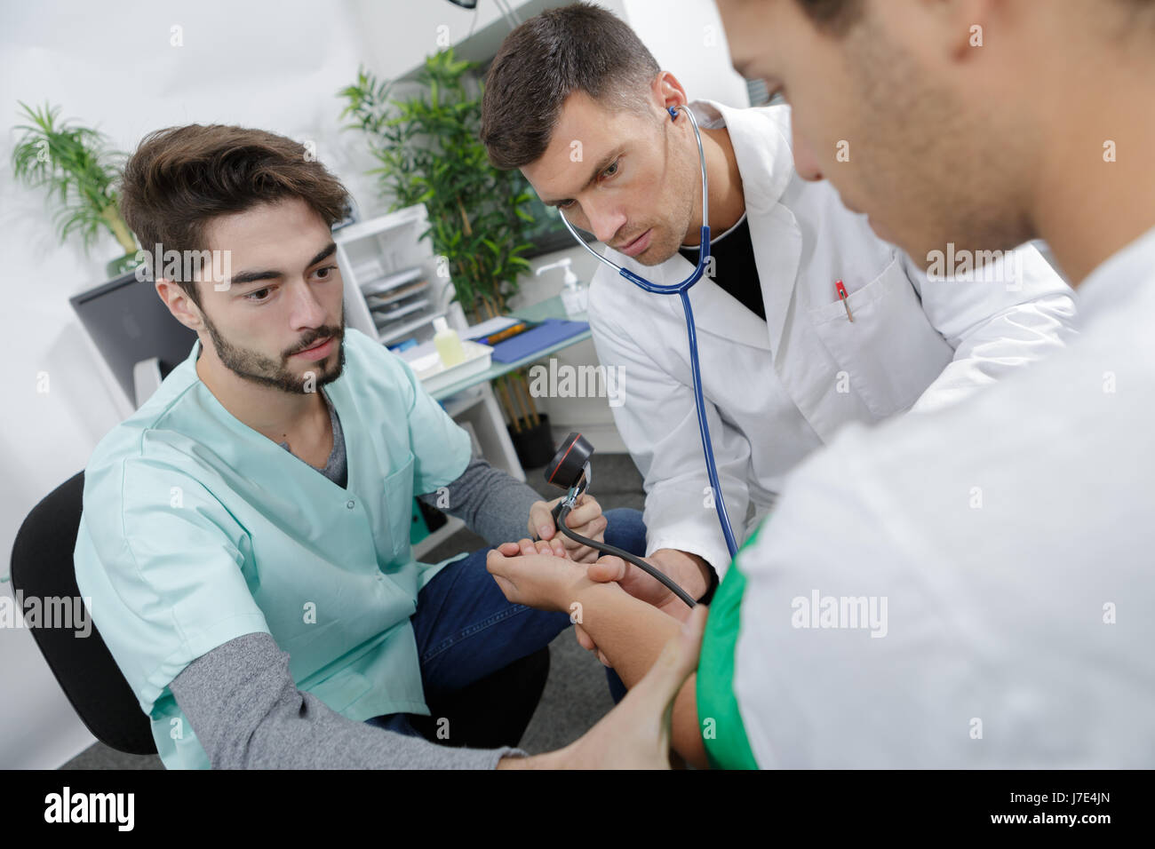 Student nurse taking patient's bloodpressure Stock Photo