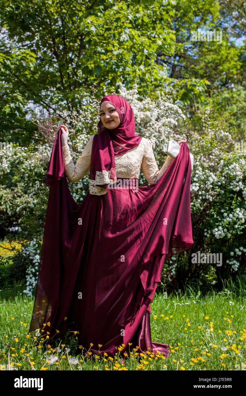 Young and beautiful girl covered, Muslim, in the sumptuous dress enjoying  spring day filled with sun, trees full blossom, and flowers around girls  Stock Photo - Alamy