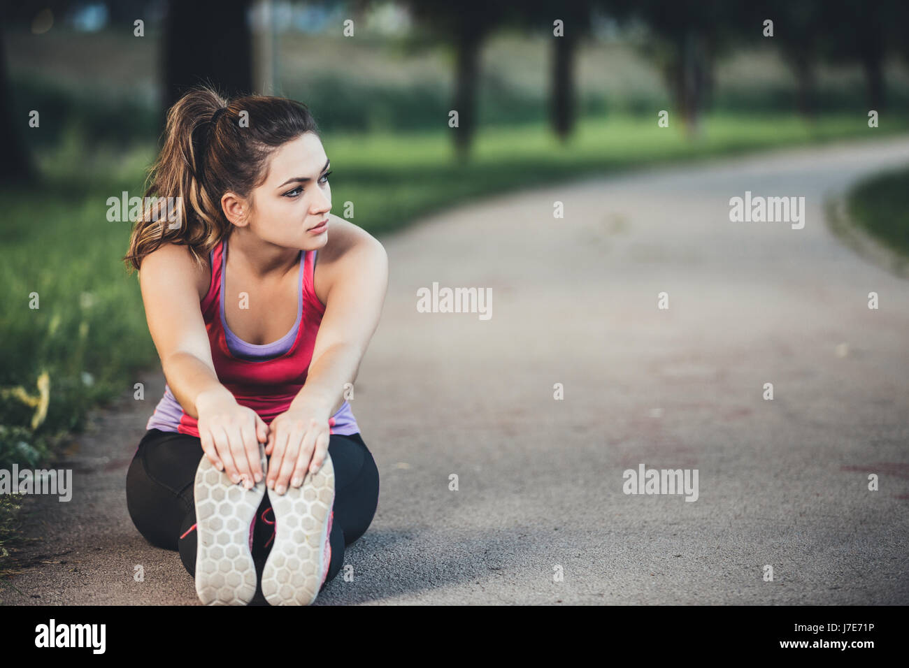 Woman is stretching before jogging. Fitness and lifestyle concept. Stock Photo