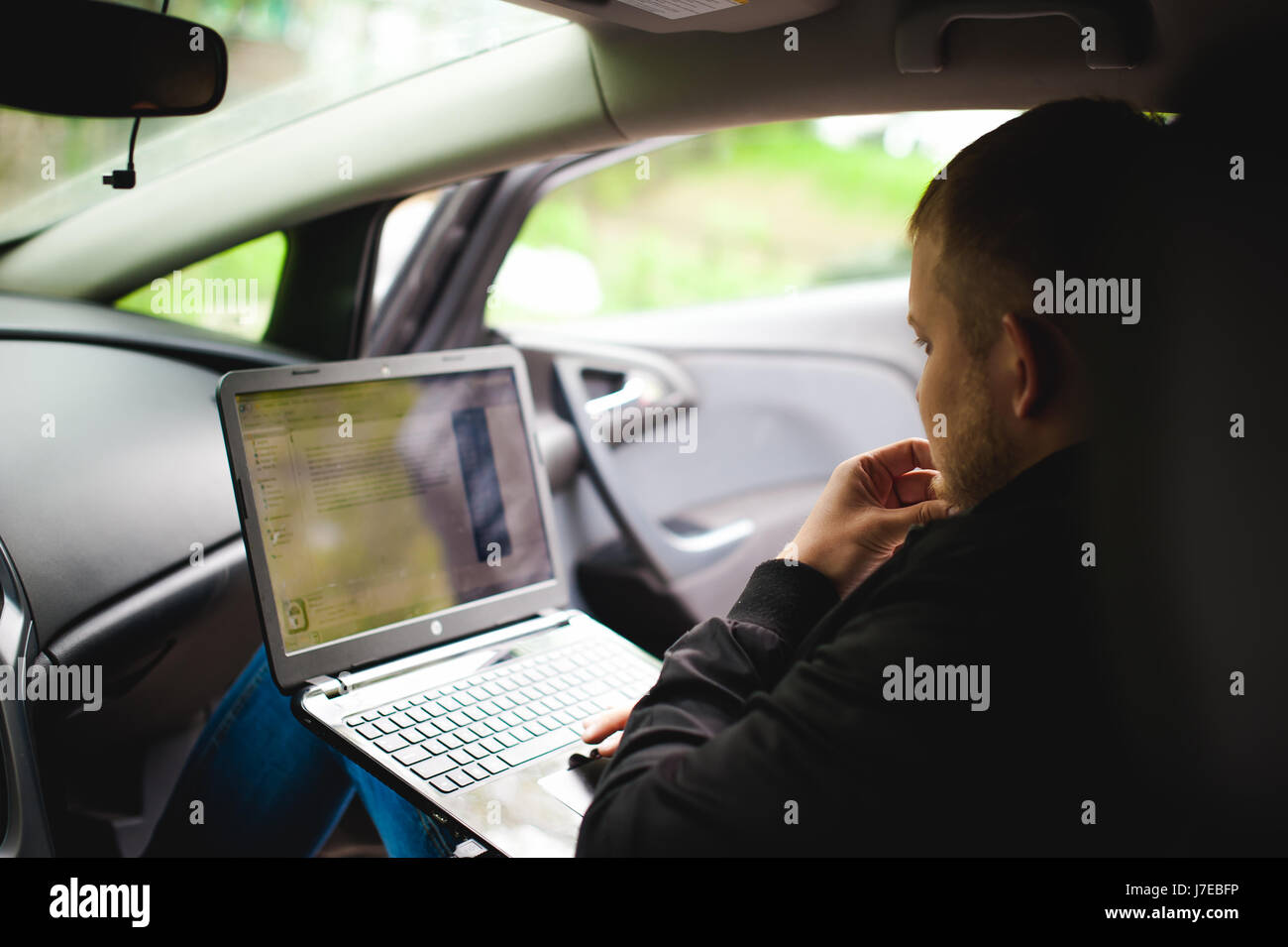 Professional man with a laptop in car tunes tuning control system ...