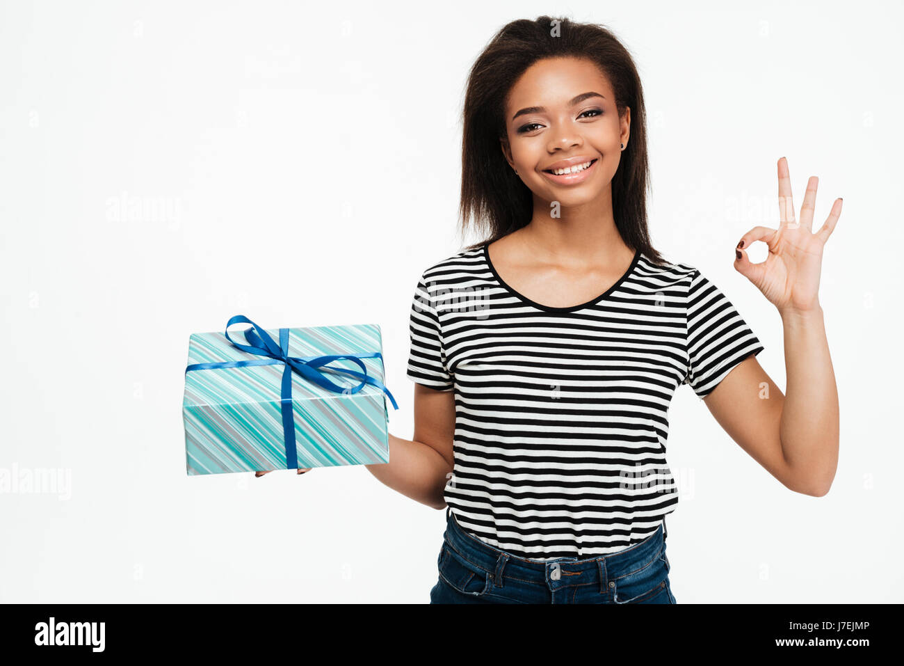 Portrait of a smiling cheerful african woman holding gift box and ...